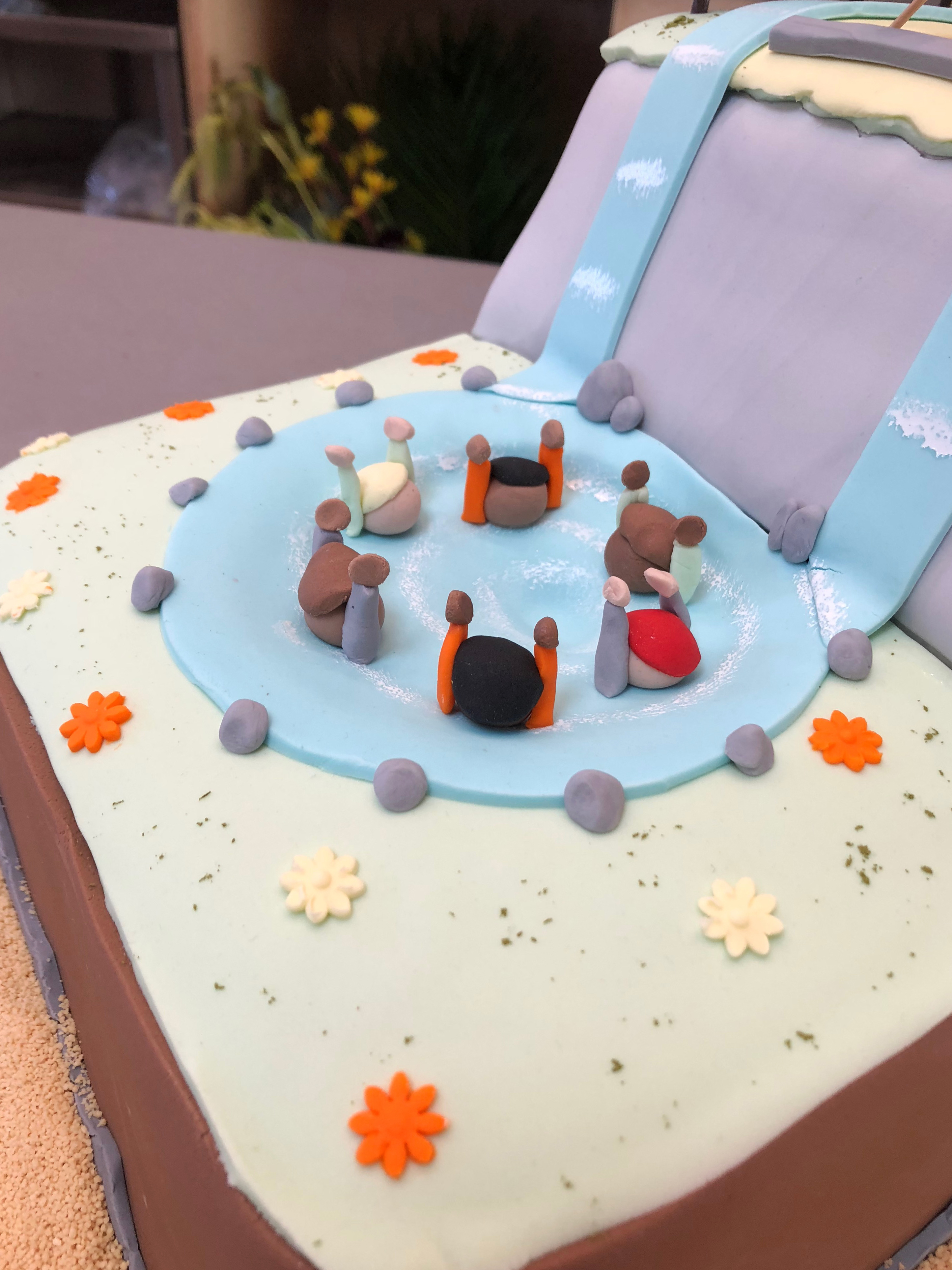 Extreme detail of figures on the cake drowing in a whirlpool surrounded by a field of flowers